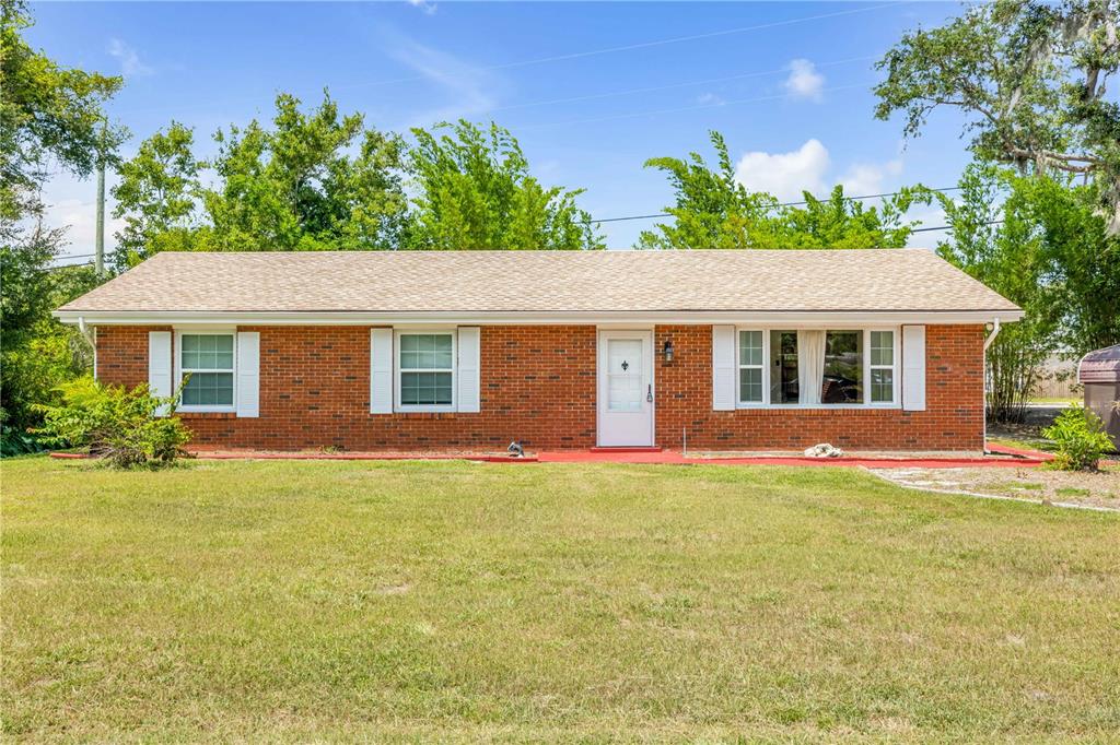 A single-story brick house with a white front door and white shutters on the windows — 5680 PALM AVENUE, PORT ORANGE, FL