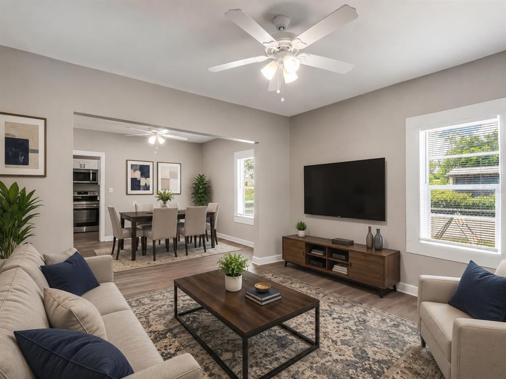 A living room with a ceiling fan, television, and dining area in the background — 1101 DR MARTIN L KING JR WAY, HAINES CITY, FL