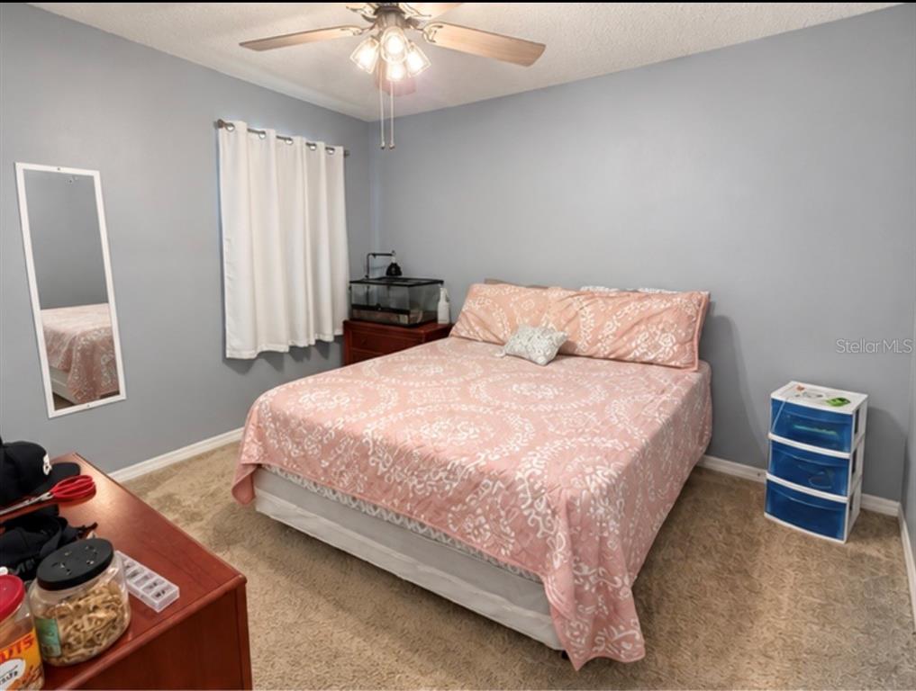 A long hallway with light gray walls and tile flooring features two dog crates — 635 AUTUMN STREAM DRIVE, AUBURNDALE, FL