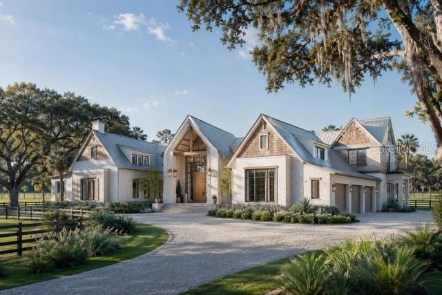 A large, multi-gabled white farmhouse with a gravel driveway and surrounding oak trees — Lot 2 SW 161 TERRACE, NEWBERRY, FL
