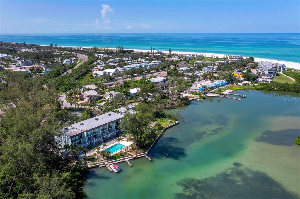 An aerial view of a waterfront condominium complex with a pool and boat docks — 490 N SHORE ROAD UNIT 6, LONGBOAT KEY, FL