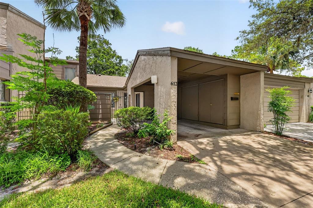An exterior view of a house with a carport, concrete driveway, and landscaped front yard — 612 WOODRIDGE DRIVE, CASSELBERRY, FL