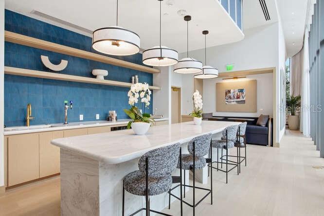A living room with a beige sofa, round coffee table, and floor-to-ceiling windows overlooking water — 3015 S YSABELLA AVENUE UNIT 1402, TAMPA, FL