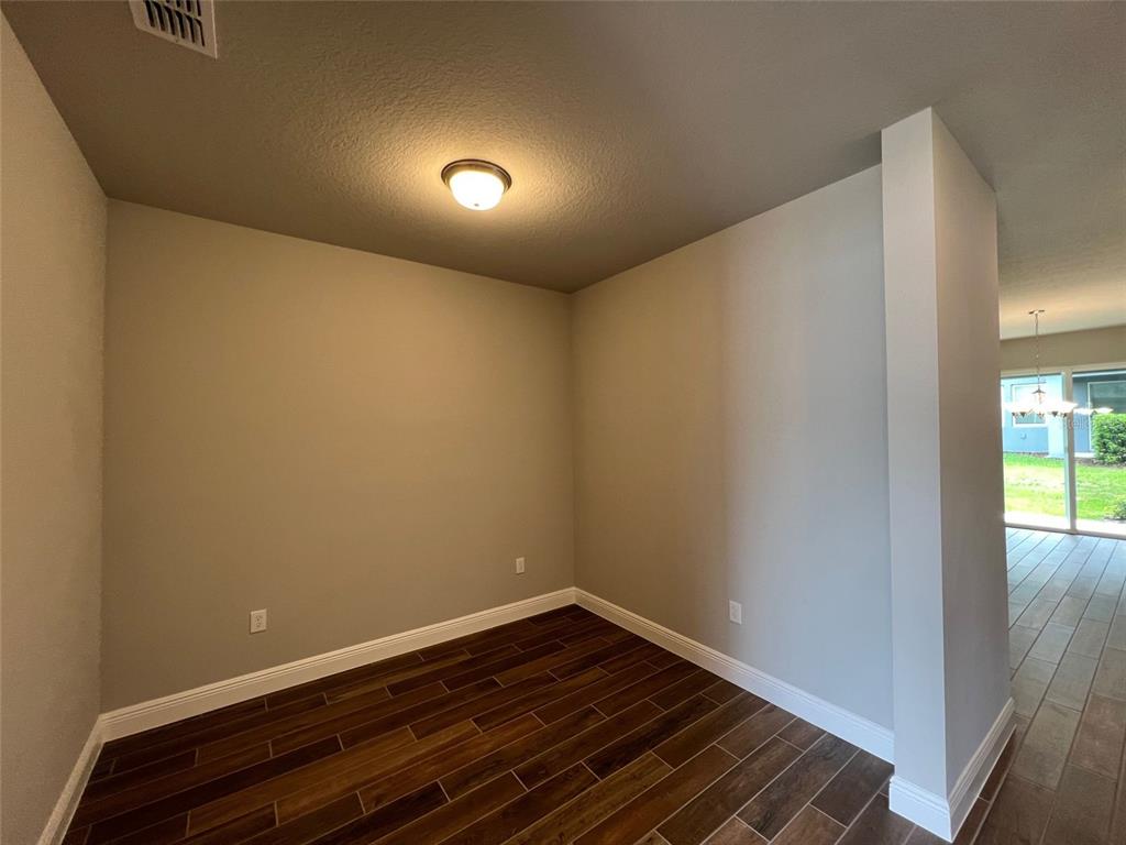 An interior room features dark wood-look tile flooring, light gray walls, and a ceiling light — 1326 MERRYDALE WAY, WINTER PARK, FL