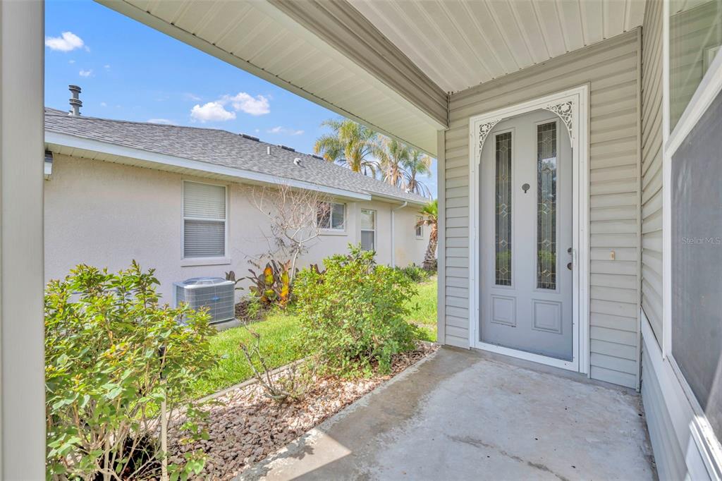 A bedroom features a wooden bed frame, matching dresser, jute rug, and light-colored walls — 21630 REGENCY PARK LN, LEESBURG, FL