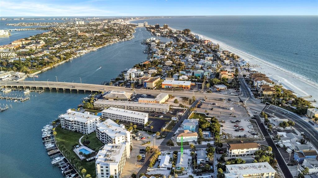 An aerial view shows a coastal town situated between the ocean and an inlet — 148 98TH AVENUE, TREASURE ISLAND, FL