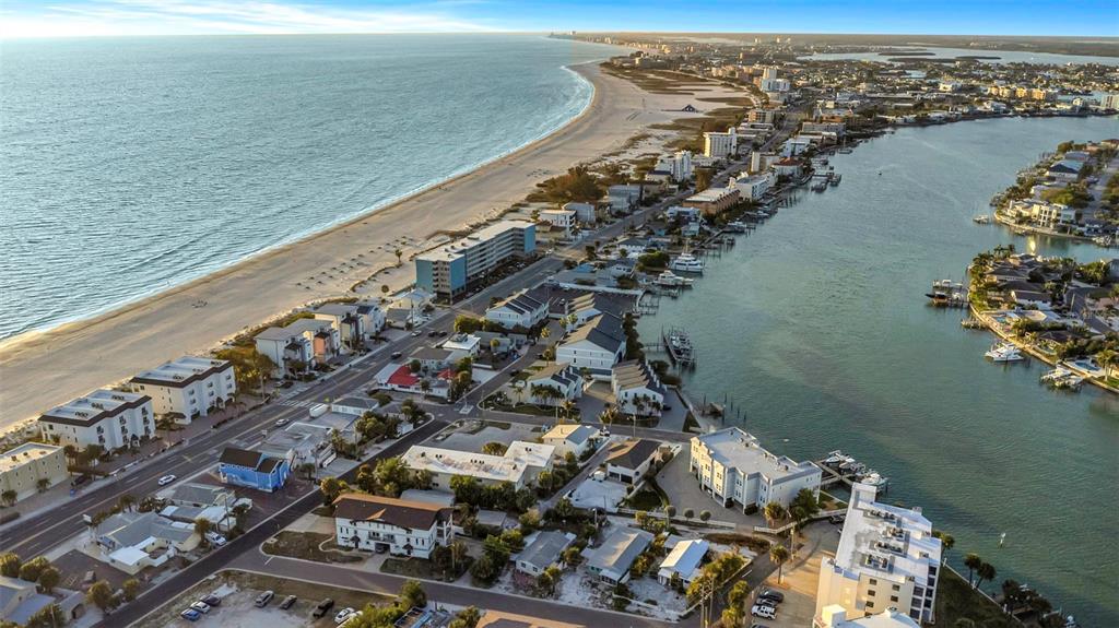 An aerial view shows a rectangular house with a shingled roof surrounded by sandy landscaping — 148 98TH AVENUE, TREASURE ISLAND, FL