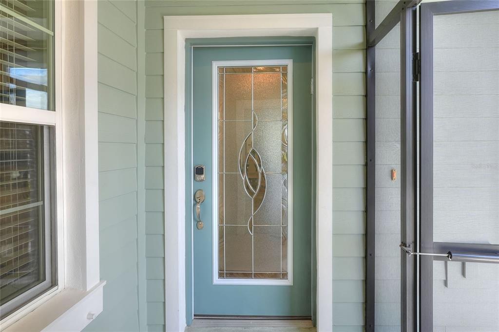 A teal front door with a decorative glass insert is set within light green siding — 13529 CIRCA CROSSING DRIVE, LITHIA, FL