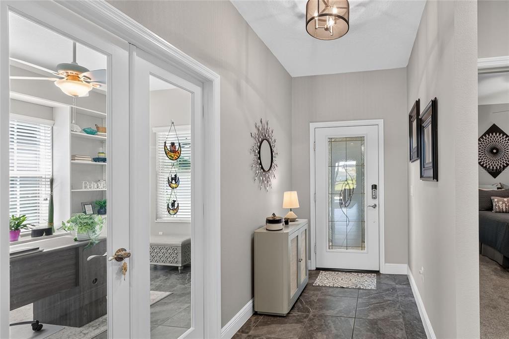 An entryway features tile flooring, a glass-paneled front door, and French doors to an office — 13529 CIRCA CROSSING DRIVE, LITHIA, FL