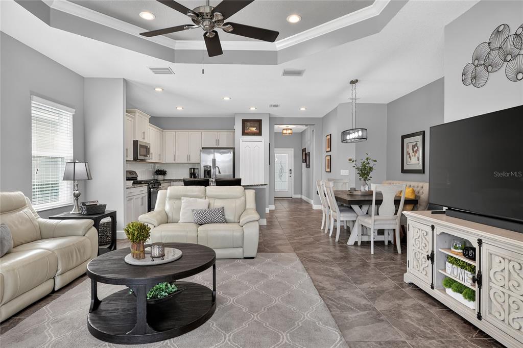An open-concept living and dining area features tile flooring, a tray ceiling, and white cabinetry — 13529 CIRCA CROSSING DRIVE, LITHIA, FL