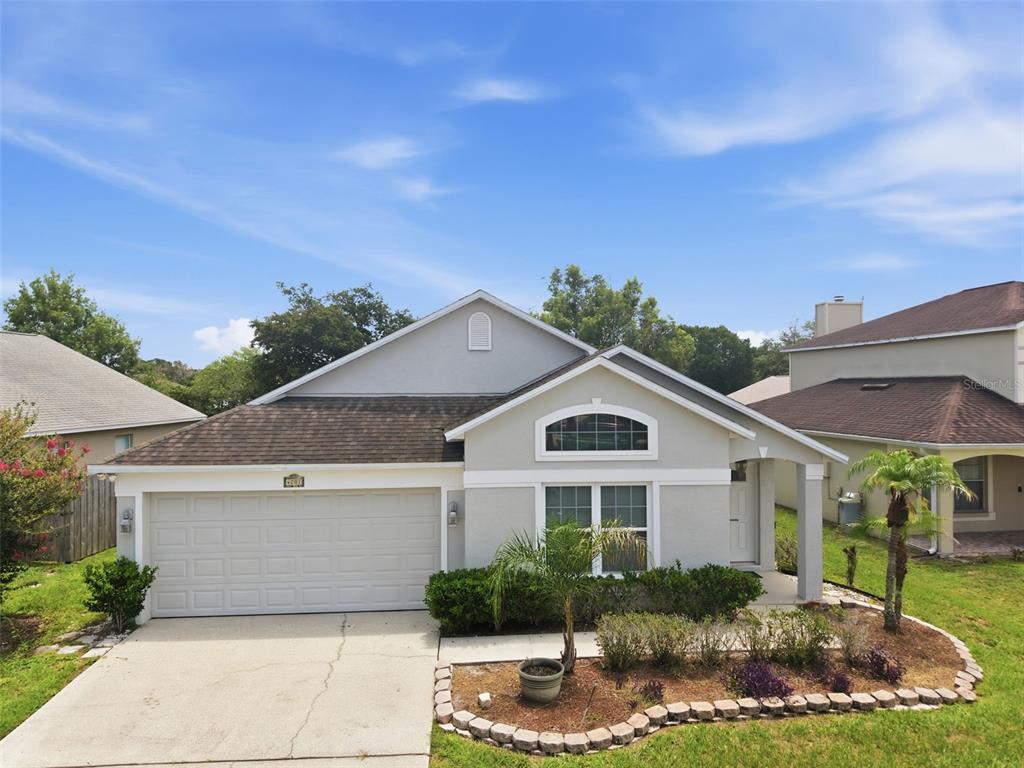 A single-story suburban house with a gray exterior, a two-car garage, and a landscaped yard — 4201 PACIFICA DRIVE, ORLANDO, FL