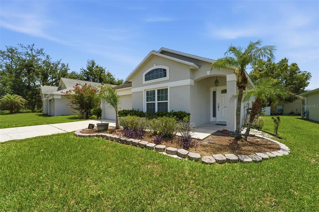 A single-story house with a light-colored exterior, a front garden, and a palm tree — 4201 PACIFICA DRIVE, ORLANDO, FL