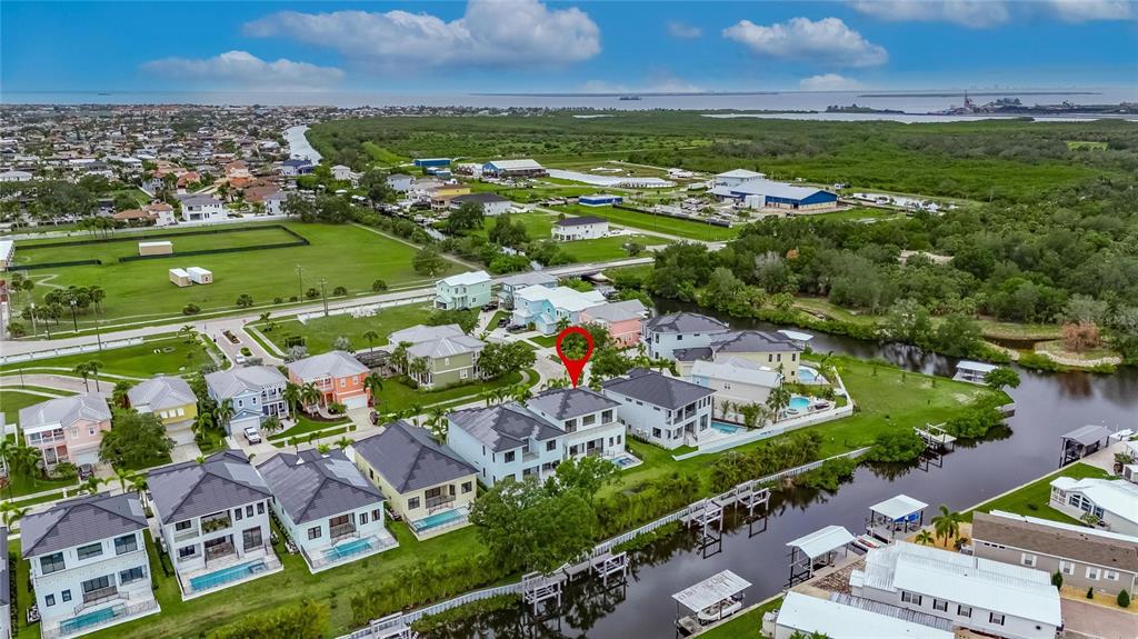 An aerial view shows a waterfront house with a pool and a red location marker — 6528 SIMONE SHORES CIRCLE, APOLLO BEACH, FL