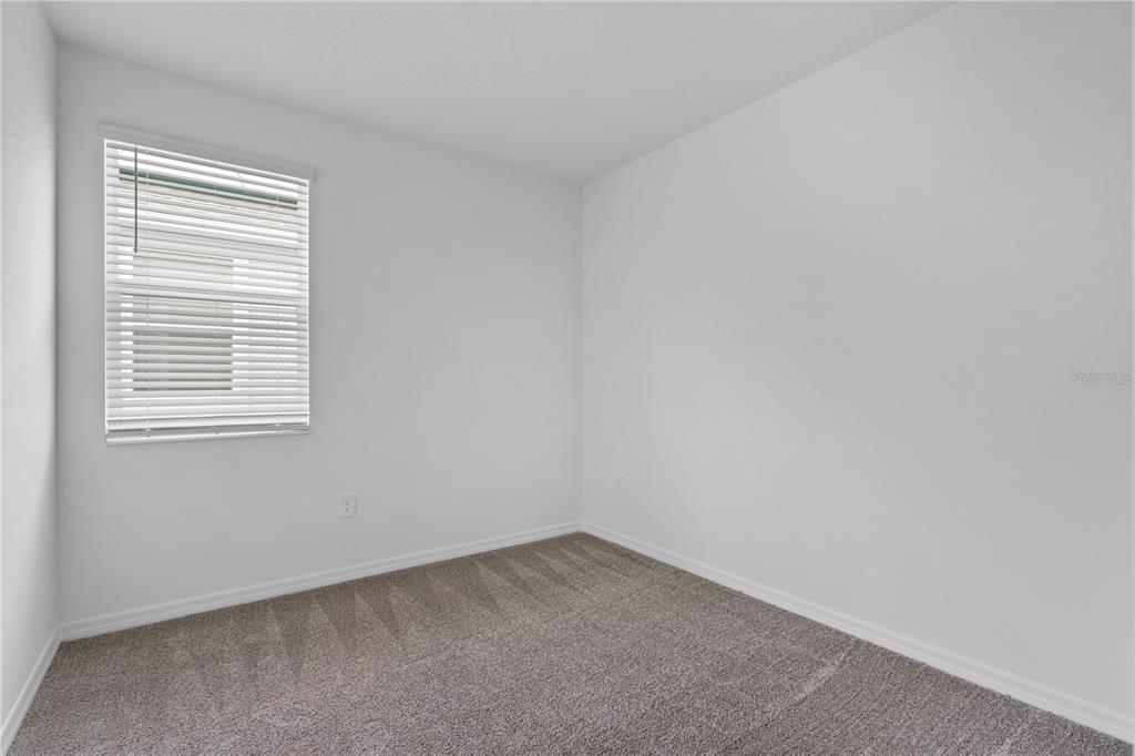 An empty bedroom features white walls, gray carpet, and a single window with white blinds — 4123 CONJUNCTION WAY, APOPKA, FL