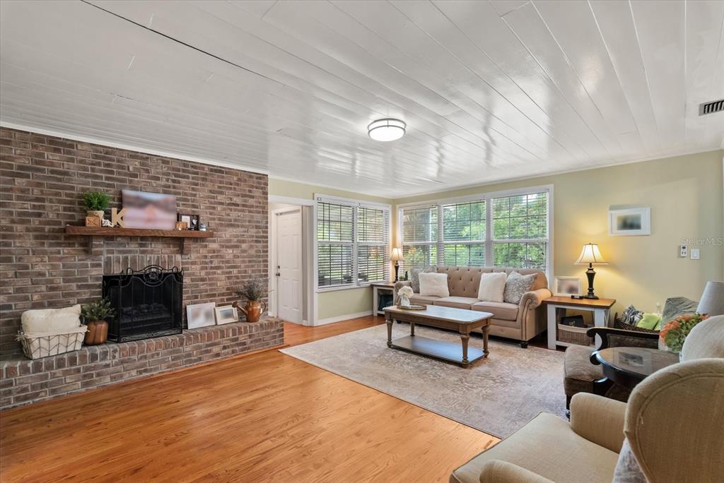 A living room features a brick fireplace, hardwood floors, and a white paneled ceiling — 37 E VANDERBILT STREET, ORLANDO, FL
