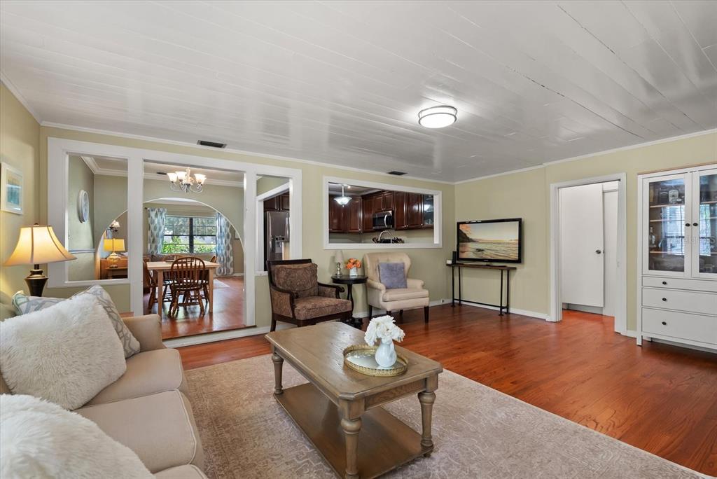 A living room with hardwood floors, a white plank ceiling, and a view into the kitchen — 37 E VANDERBILT STREET, ORLANDO, FL