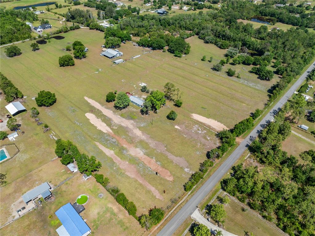 An aerial view shows a rural property with a house, outbuildings, and open pasture land — 0 LA SALLE AVENUE, ST CLOUD, FL