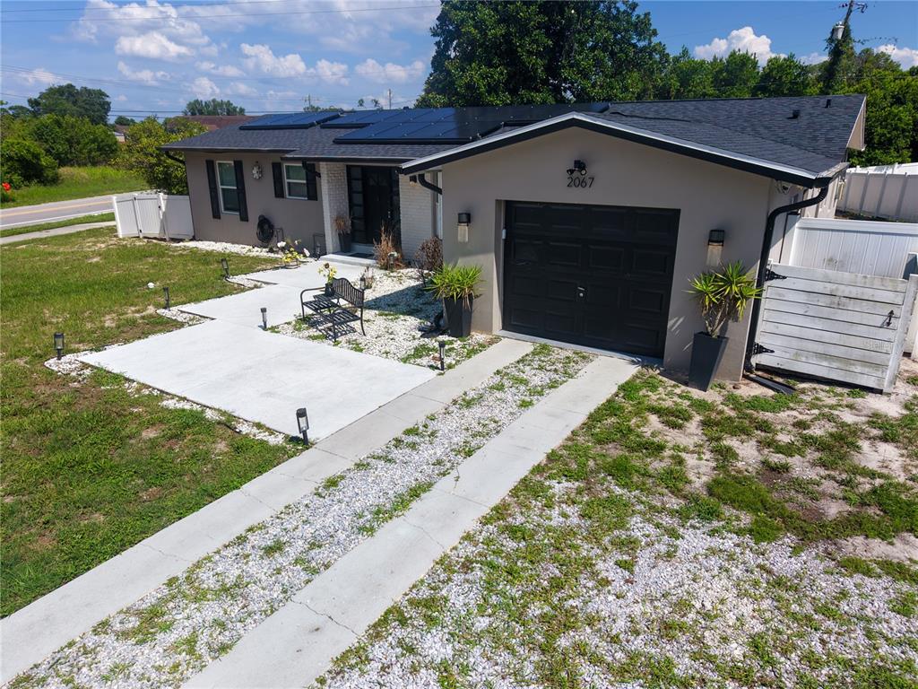 An aerial view of a single-story house with a gravel driveway and solar panels — 2067 E BARLINGTON DRIVE, DELTONA, FL