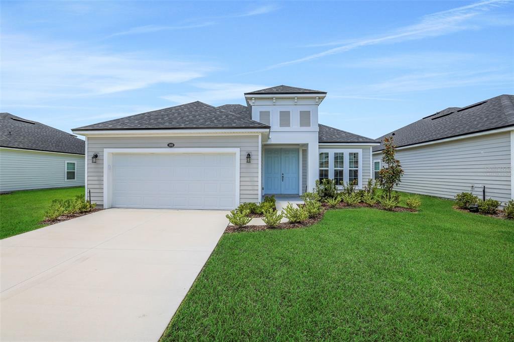 A single-story house with light gray siding, a two-car garage, and a light blue front door — 3848 HOLSTEIN WAY, GREEN COVE SPRINGS, FL