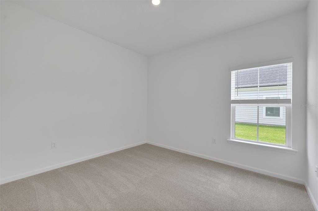 An empty bedroom with white walls, beige carpeting, and a single window — 3848 HOLSTEIN WAY, GREEN COVE SPRINGS, FL