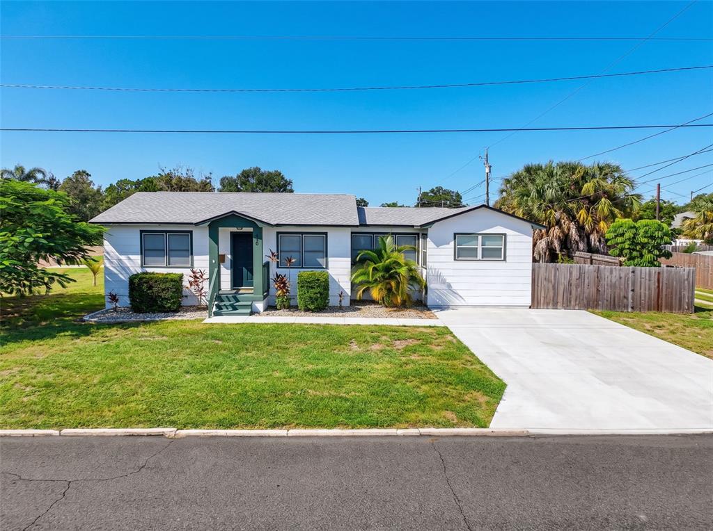 A single-story white house with a green front door and a concrete driveway — 440 42ND STREET N, ST PETERSBURG, FL