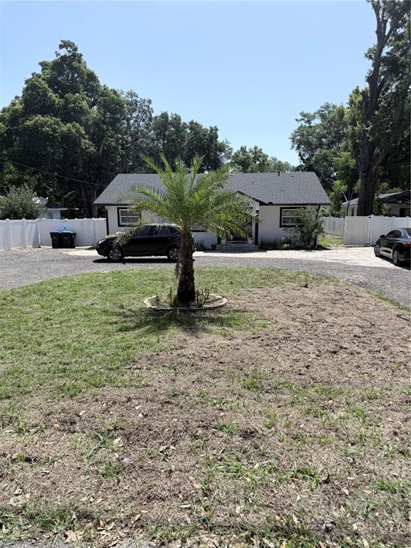 A single-story house with a palm tree in the front yard and a gravel driveway — 1243 DINGENS AVENUE, WINDERMERE, FL
