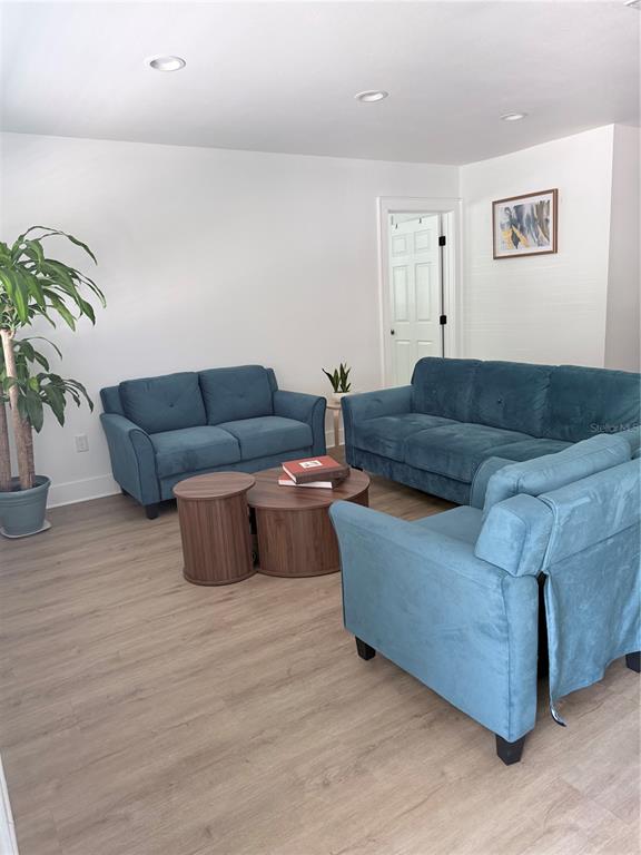 A living room features blue upholstered furniture, a round wooden coffee table, and light flooring — 1243 DINGENS AVENUE, WINDERMERE, FL