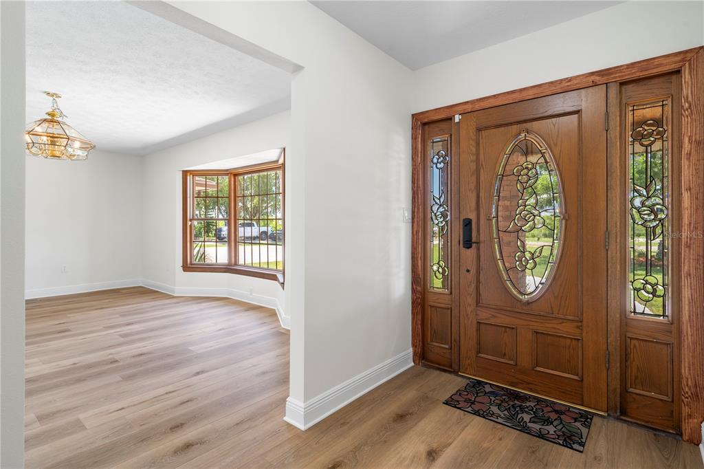 An entryway with a wood front door and sidelights leads into a room with wood flooring — 404 DICKMAN DRIVE SW, RUSKIN, FL