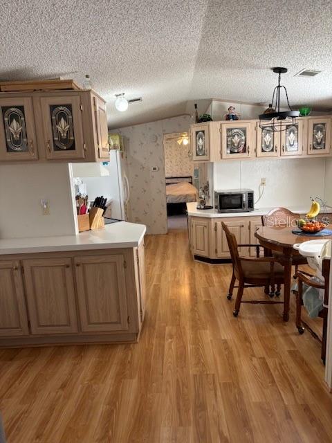 A kitchen with light wood cabinets, laminate flooring, and a dining area with a table — 1749 ELIZABETH STREET, NEW SMYRNA BEACH, FL