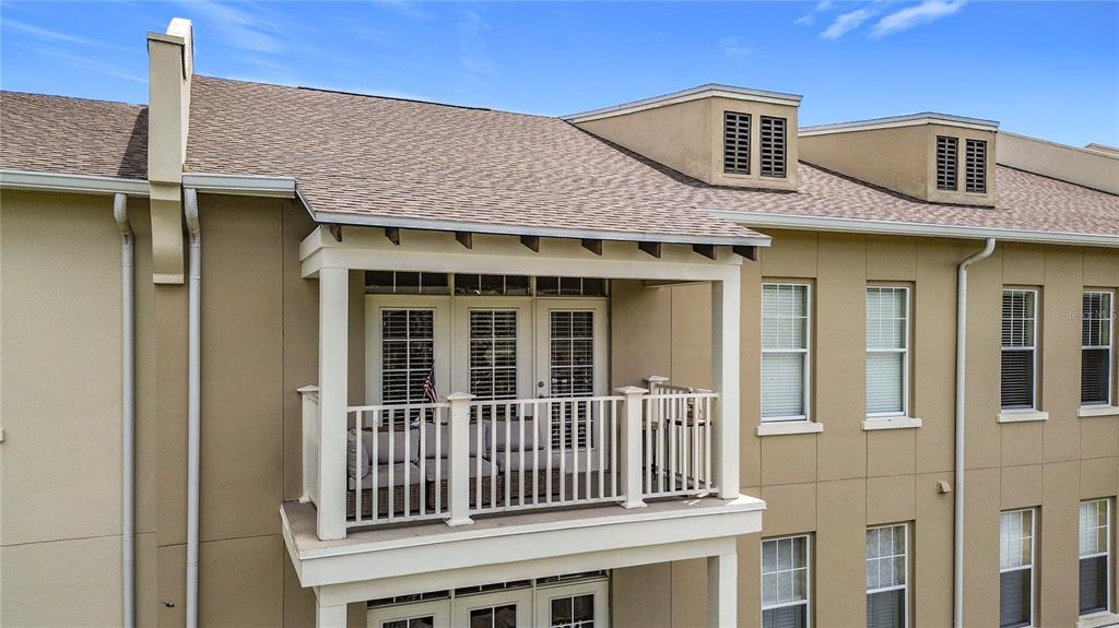 An exterior view of a multi-story building featuring a balcony with white railings — 1231 WRIGHT CIR UNIT 308, CELEBRATION, FL