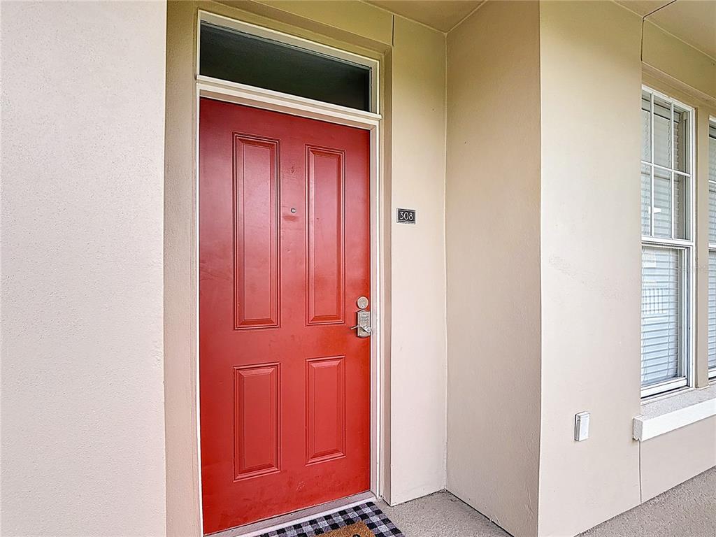 A red front door with a transom window and the number 308 on the wall — 1231 WRIGHT CIR UNIT 308, CELEBRATION, FL