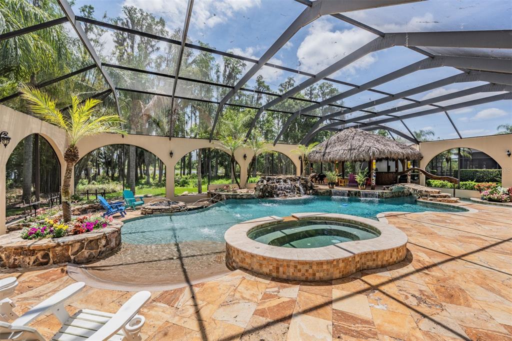 An aerial view shows several large houses with pools near a lake and trees — 21246 QUIET HAVEN COURT, LAND O LAKES, FL