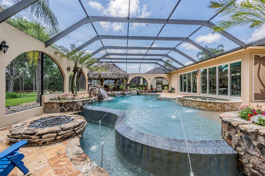 An aerial view shows a house with a screened-in pool, patio, and landscaped yard — 21246 QUIET HAVEN COURT, LAND O LAKES, FL