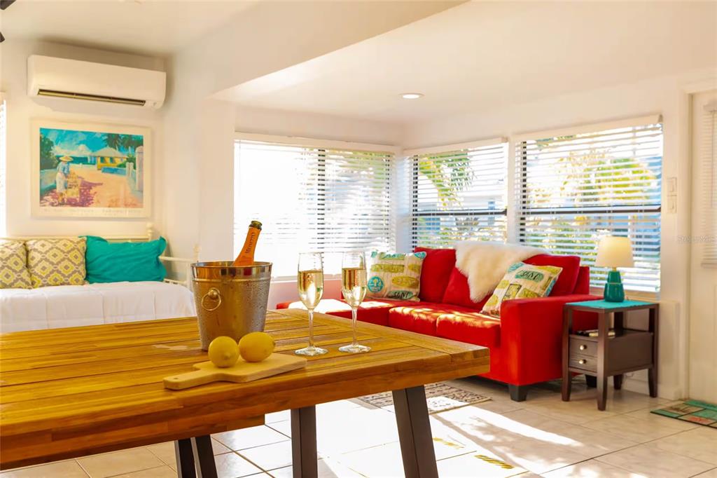 A living room features a red sofa, a wooden dining table, and a daybed — 839 3RD STREET N, SAFETY HARBOR, FL