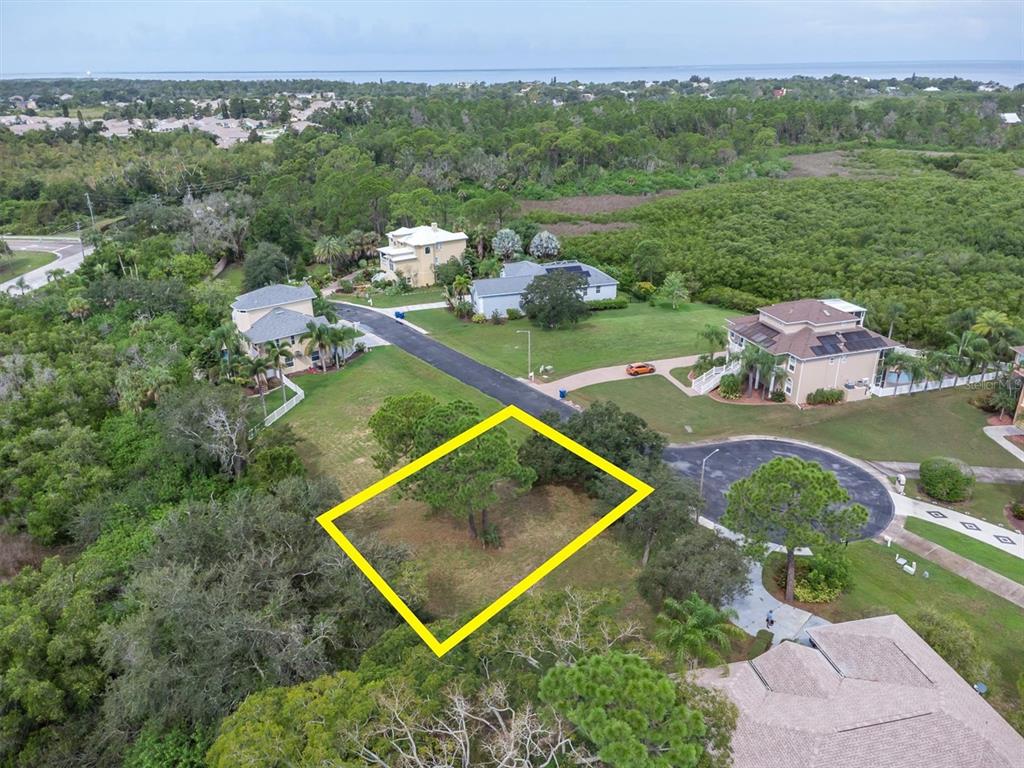 An aerial view shows a vacant residential lot outlined in yellow near a paved cul-de-sac — 3034 SHEPPARDS CROOK, HOLIDAY, FL