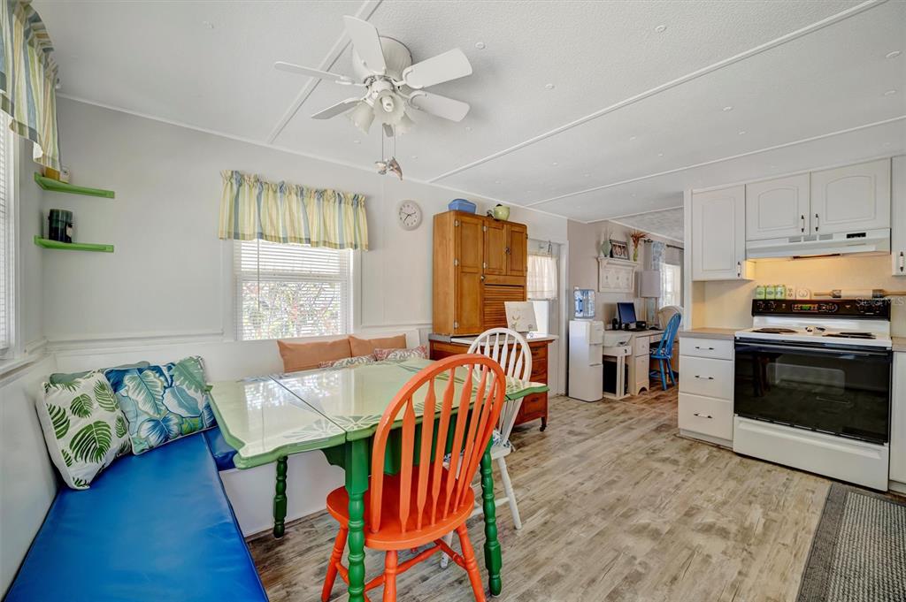 A kitchen and dining area with a blue bench seat, green table, and white cabinets — 104 SAINT KITTS WAY, APOLLO BEACH, FL