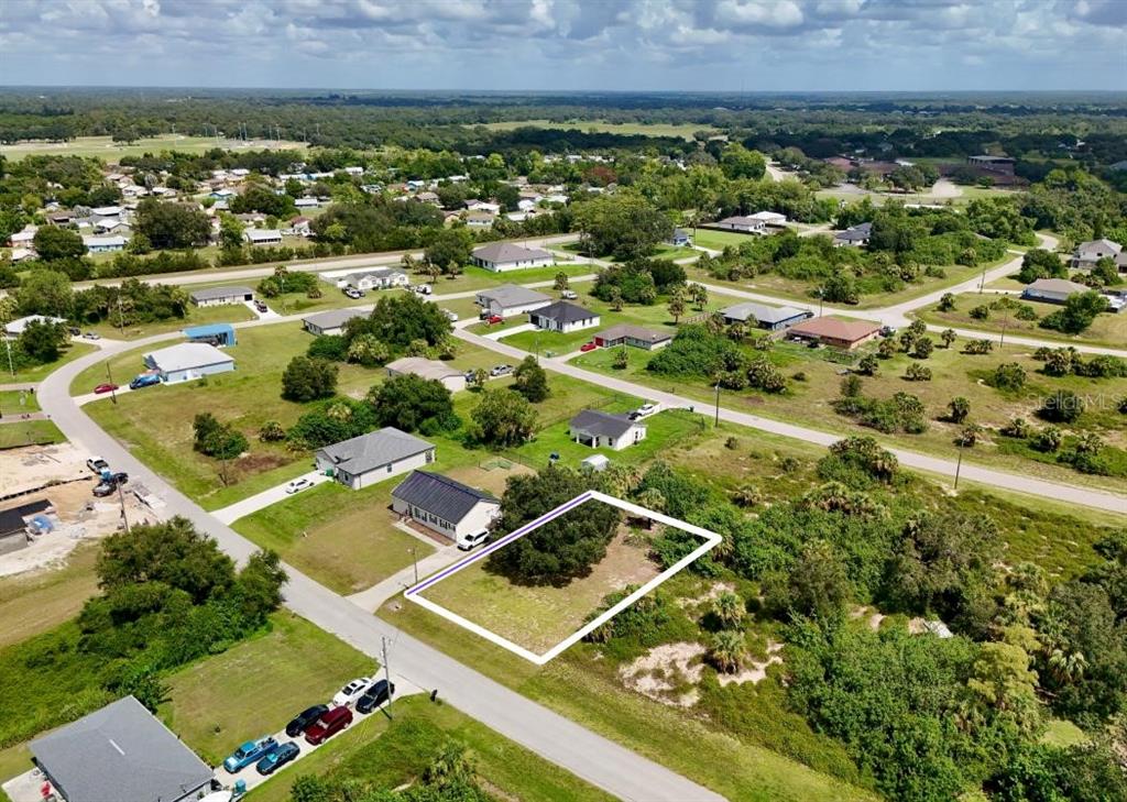 An aerial view shows a vacant residential lot outlined in white next to a house — 2038 S MONTANA CIRCLE, LABELLE, FL