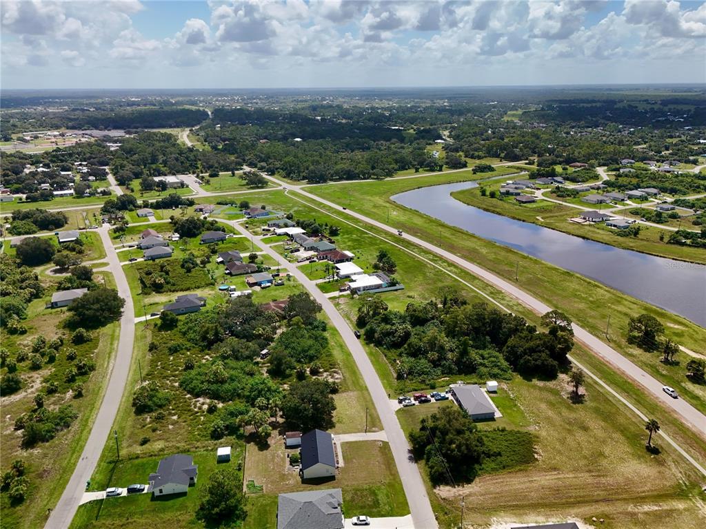 An aerial view shows a residential neighborhood with houses, a canal, and surrounding vegetation — 2038 S MONTANA CIRCLE, LABELLE, FL