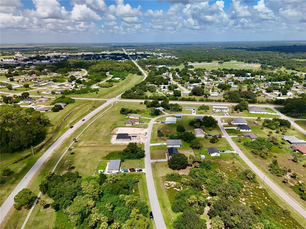 An aerial view shows a suburban neighborhood with houses, paved roads, and surrounding green space — 2038 S MONTANA CIRCLE, LABELLE, FL