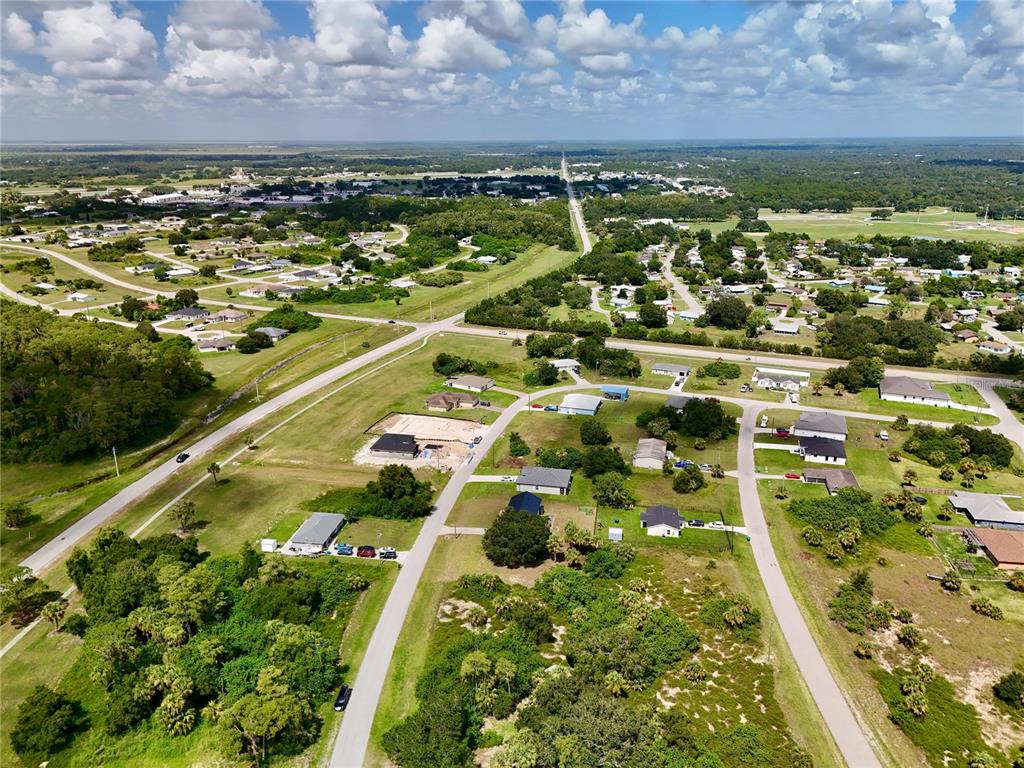 An aerial view shows a residential neighborhood with scattered houses, paved roads, and surrounding vegetation — 2038 S MONTANA CIRCLE, LABELLE, FL