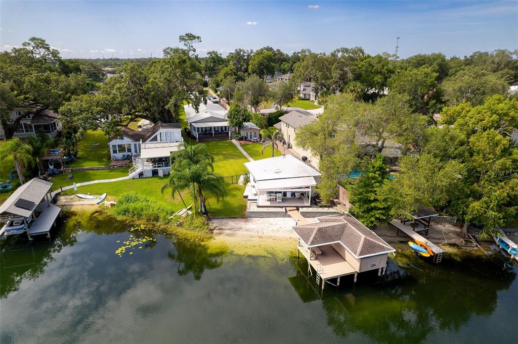 An aerial view shows waterfront houses with private docks, green lawns, and mature trees — 503 GATLIN AVENUE, ORLANDO, FL