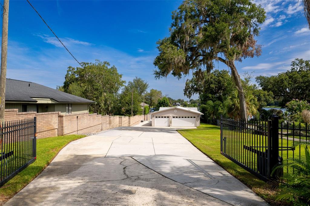 A concrete driveway leads to a detached two-car garage behind a gated residential property — 503 GATLIN AVENUE, ORLANDO, FL