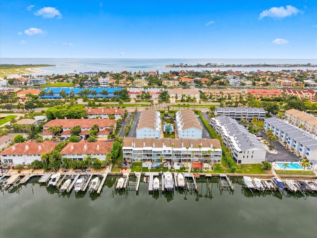 An aerial view shows waterfront townhomes with private boat slips along a canal — 751 PINELLAS BAYWAY  S UNIT 19, TIERRA VERDE, FL
