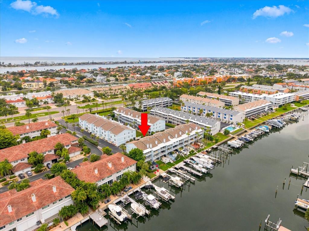 An aerial view shows a multi-story waterfront condominium complex with boat slips and docks — 751 PINELLAS BAYWAY  S UNIT 19, TIERRA VERDE, FL