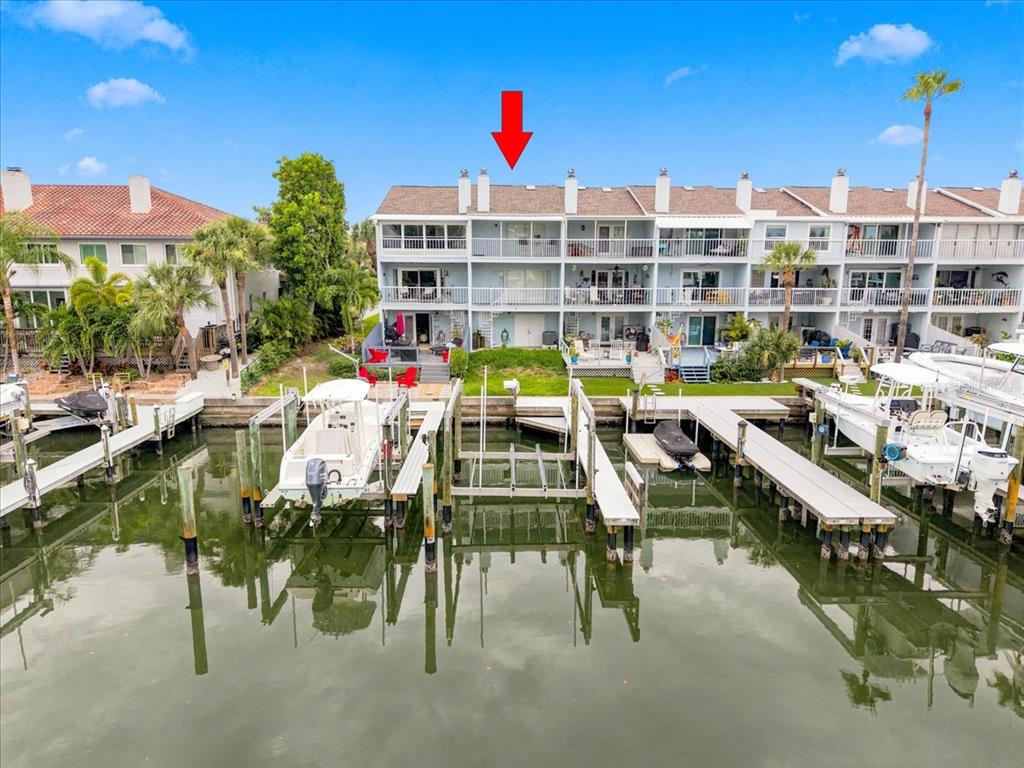 An exterior view of a multi-story waterfront condominium building with private boat slips — 751 PINELLAS BAYWAY  S UNIT 19, TIERRA VERDE, FL