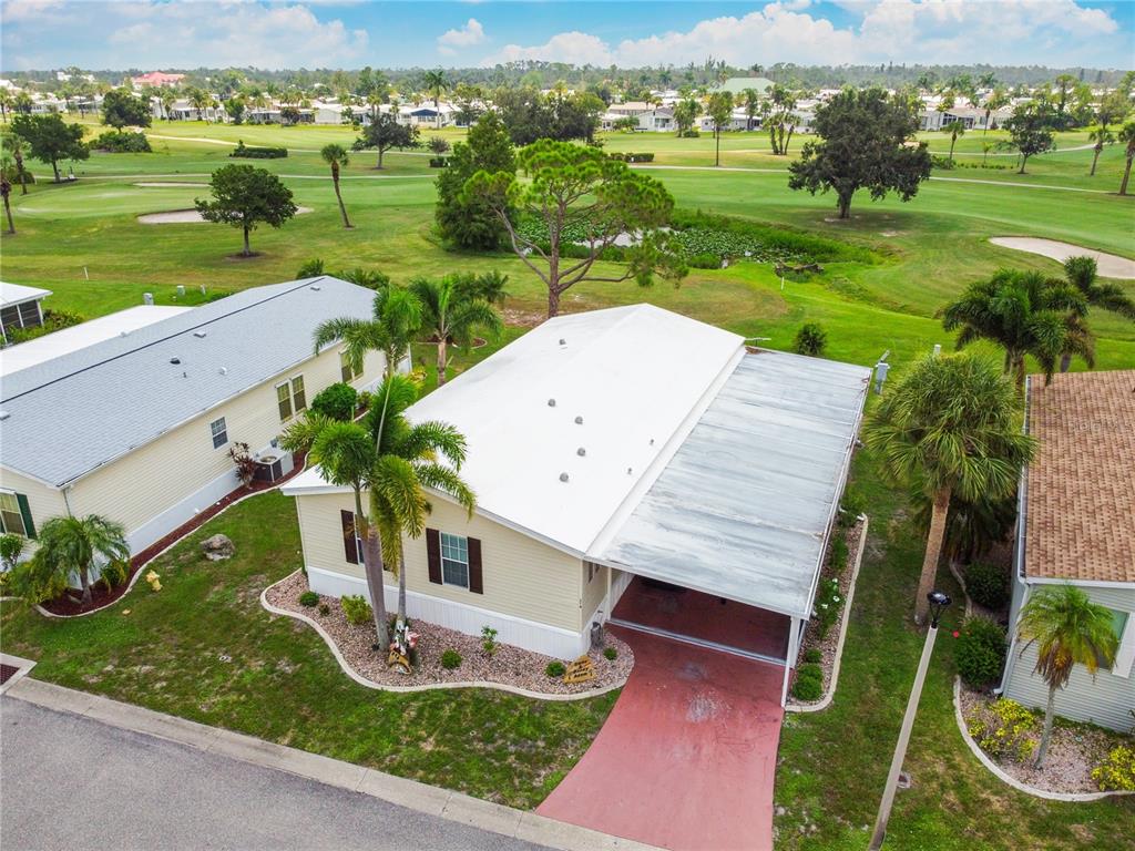 A light yellow manufactured home features a screened-in carport and a small landscaped front yard — 2100 KINGS HIGHWAY UNIT 314, PORT CHARLOTTE, FL