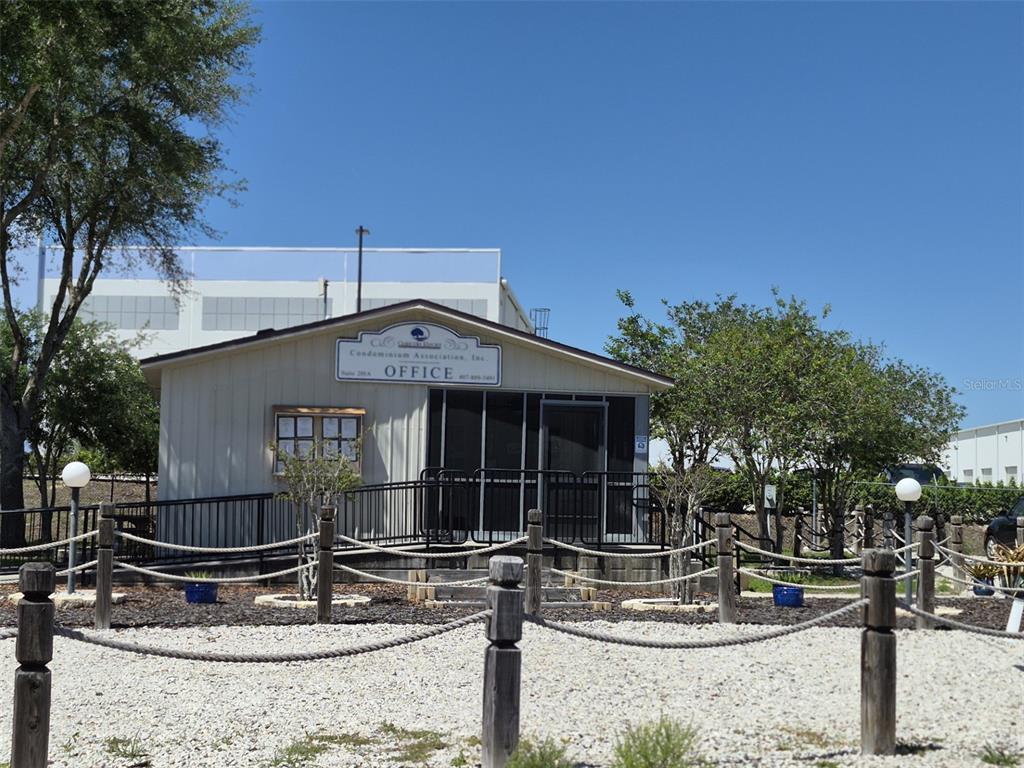 A small, light-colored office building with a screened porch and a rope-fenced gravel yard — 3000 CLARCONA ROAD UNIT 530, APOPKA, FL