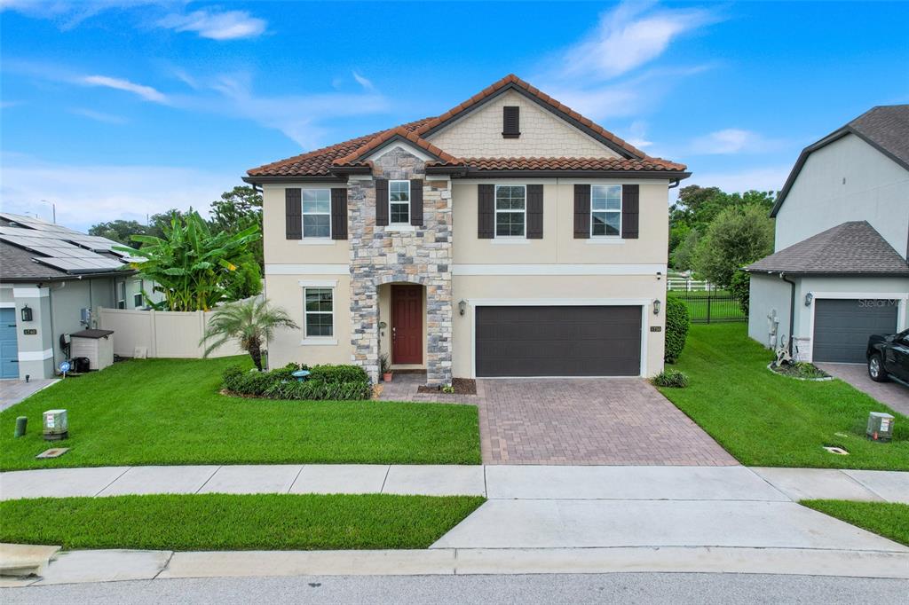 A two-story suburban house with a stone facade, red tile roof, and a paved driveway — 1750 STANDING ROCK CIRCLE, OAKLAND, FL
