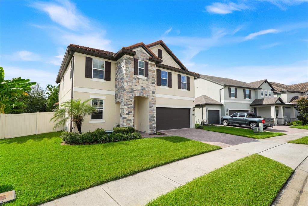 A two-story suburban house with a stone facade, a two-car garage, and a manicured lawn — 1750 STANDING ROCK CIRCLE, OAKLAND, FL