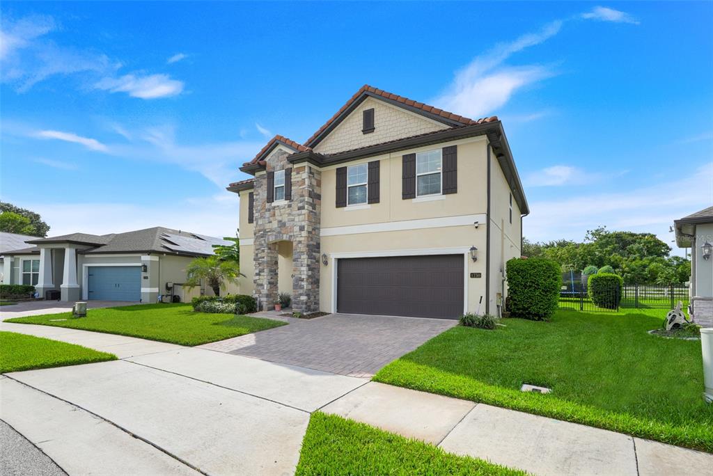 A two-story house with a stone-accented entryway, a two-car garage, and a paved driveway — 1750 STANDING ROCK CIRCLE, OAKLAND, FL